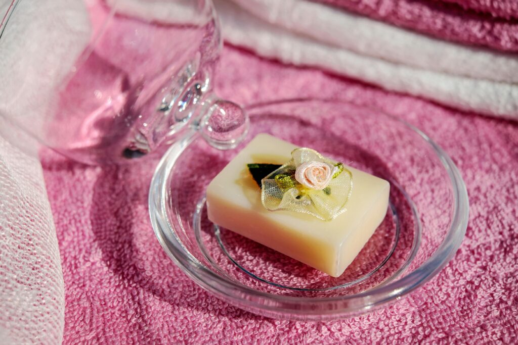 Elegant soap bar with floral decor on a pink towel, evoking relaxation and beauty.