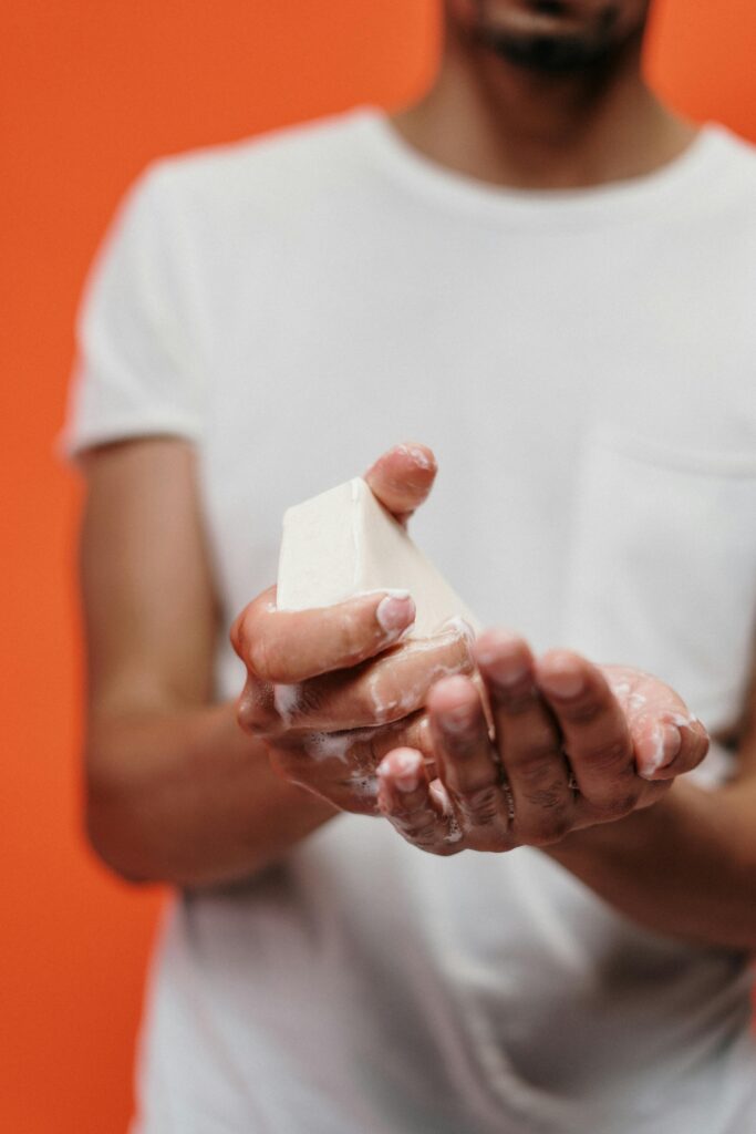 Close-up of a man washing hands with bar soap, promoting hygiene and cleanliness.